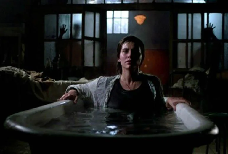 mujer vestida y de noche dentro de una bañera llena de agua